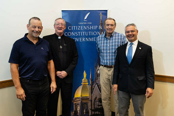 four men standing in front of CCCG banner