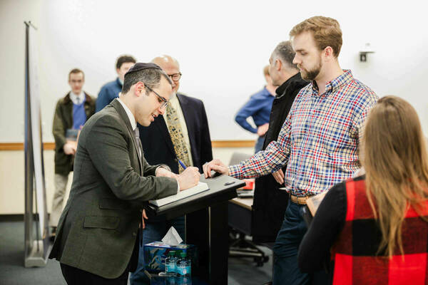 Mark signs copies of his book "The Nature of Law" following his public lecture.