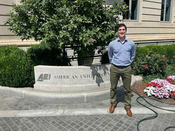 Rocco Giannotti poses in front of the AEI sign.