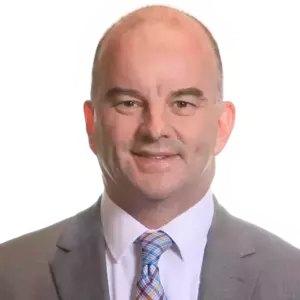 Headshot of a man with short hair, wearing a gray suit and a plaid tie.  He is smiling.
