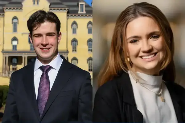 Liam Kelly in a dark suit and purple tie by Notre Dame's Main Building. Beside him, Maria, a smiling woman with light brown hair in a white turtleneck.