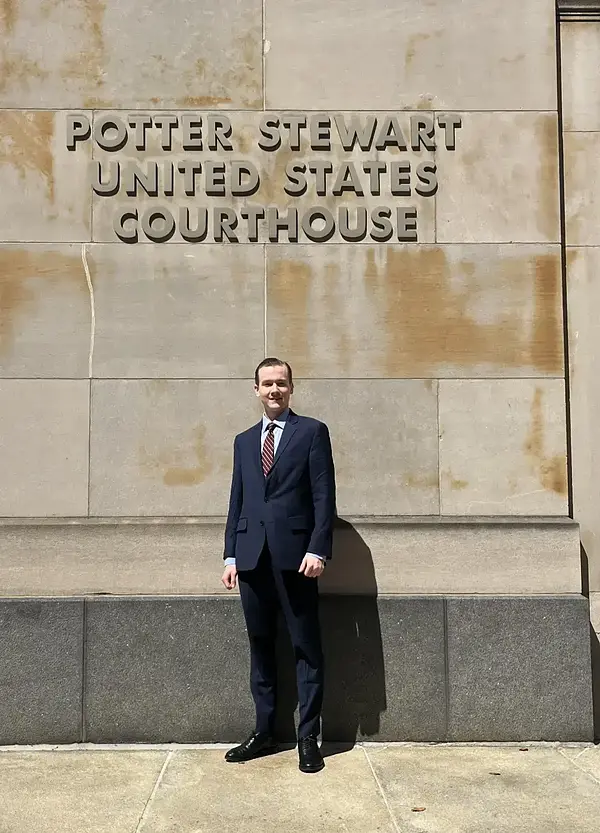 Kevin Bizily  posing in front of the Courthouse for his internship with Judge Amul Thapar